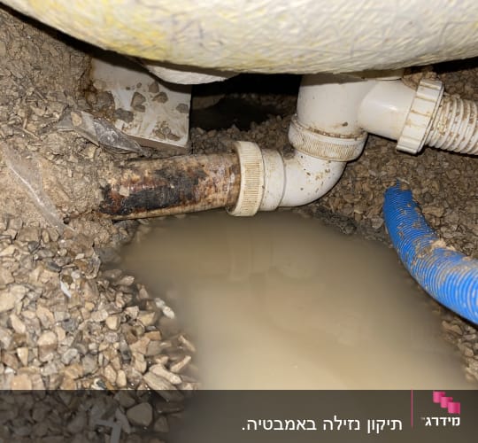 צינור דולף עם מים עומדים על הקרקע